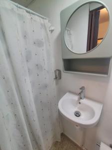 a bathroom with a sink and a mirror at La Guarida de Mela in Santo Domingo +6 photos