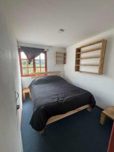 ein Schlafzimmer mit einem Bett in einem Zimmer mit einem Fenster in der Unterkunft cabañas fariña in Llanquihue