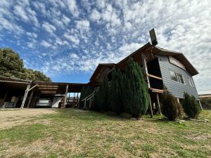 eine Scheune mit Bäumen davor in der Unterkunft cabañas fariña in Llanquihue