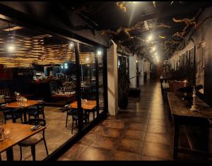 Un restaurante con mesas y sillas en una sala. en Regalia Suites, en Kraaifontein 22 fotos más