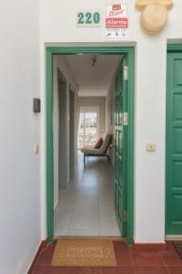a hallway with a green door and a chair at Mar Airport-Park by Babiniliving in Costa de Antigua