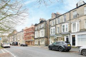 a street with buildings and cars parked on the street at Penthouse Parade Apartment, Sleeps 6 in Harrogate