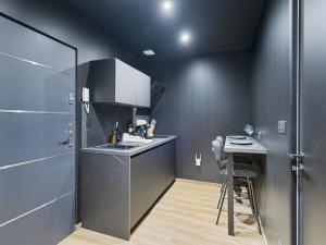 a kitchen with black walls and a counter and a stool at Cinquante Nuances Ponotes in Le Puy-en-Velay