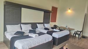 two large beds in a room with a table at Blue Nile Homestay Kotagiri in Kotagiri +3 photos