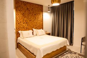 Sky rooftop luxury suites في دوريس: غرفة نوم بها سرير وجدار من الطوب +18 صورة