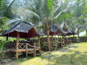 a row of gazebos with palm trees in front at LYSA Hotel in Xóm Ðèn +6 photos