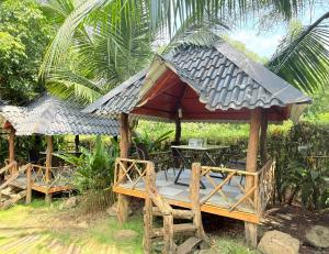 a gazebo with a table and chairs in a forest at LYSA Hotel in Xóm Ðèn