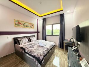 a hotel room with a bed and a tv at LYSA Hotel in Xóm Ðèn