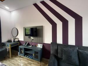 a living room with a couch and a tv on a wall at LYSA Hotel in Xóm Ðèn