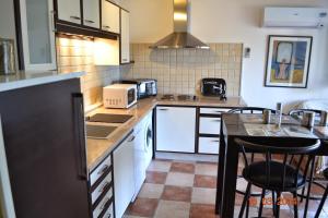 une cuisine avec des armoires blanches et un comptoir dans l'établissement Rez-de-villa Taglio-Isolaccio, à Taglio-Isolaccio