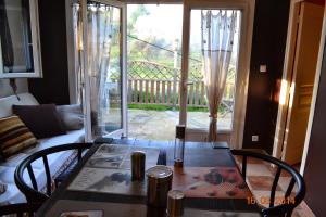 une table de salle à manger avec des chaises et une vue sur un porche dans l'établissement Rez-de-villa Taglio-Isolaccio, à Taglio-Isolaccio 2 autres photos