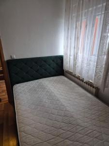 a bed in a room next to a window at Daily rental apartment Travnik in Travnik