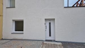 a white building with a door and two windows at Stadtnah an der Förde 5704 in Flensburg