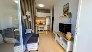 a living room with a couch and a tv and a kitchen at Apartamento Cabo de Palos - La Manga con Aire Acondicionado in Cartagena