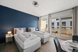 a living room with two beds and a table with a dining room at RANGE - 2 Apartments - Küche - WLAN - Netflix - Balkon - 1-6 Personen in Fellbach