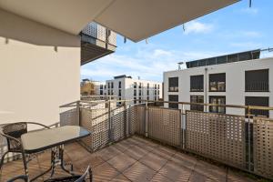a balcony with a table and chairs and buildings at RANGE - 2 Apartments - Küche - WLAN - Netflix - Balkon - 1-6 Personen in Fellbach
