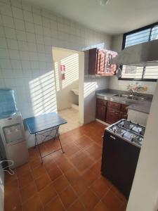 a small kitchen with a table and a stove at La Guarida de Mela in Santo Domingo