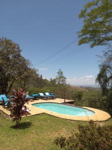 a swimming pool in a yard with lounge chairs at Hotel Fazenda Casa Mato in Taubaté
