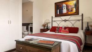 ein Schlafzimmer mit einem Bett und einem Gemälde an der Wand in der Unterkunft En el Corazón de Salta in Salta