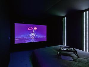 a bedroom with a flat screen tv on the wall at Ciné-Ponot in Le Puy-en-Velay