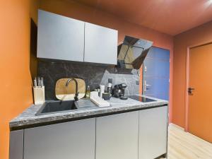 a kitchen with white cabinets and a sink at Ciné-Ponot in Le Puy-en-Velay