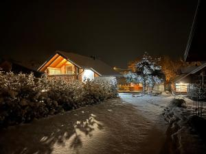a house at night with snow on the ground at Laki house in Jasień