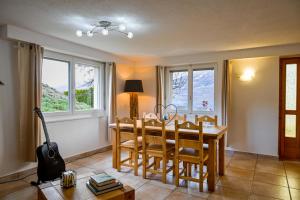 a dining room with a table and chairs and windows at Le Cerisier in Erde +7 photos