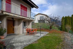 a patio with a table and chairs in front of a house at Le Cerisier in Erde
