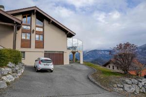 a car parked in the driveway of a house at Le Cerisier in Erde