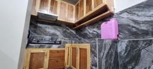 a kitchen with wooden cabinets and a pink object on the counter at EJ Cozy Transient in Baguio in Tuba