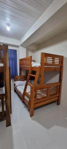 two bunk beds in a room with a window at EJ Cozy Transient in Baguio in Tuba