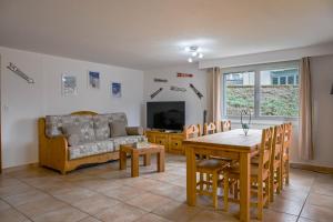a living room with a couch and a table at Le Cerisier in Erde
