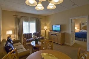 a hotel room with a bed and a living room at The Cove at Yarmouth in West Yarmouth