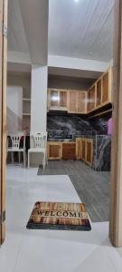 a kitchen with wooden cabinets and a rug on the floor at EJ Cozy Transient in Baguio in Tuba