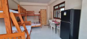 a dorm room with a refrigerator and bunk beds at EJ Cozy Transient in Baguio in Tuba