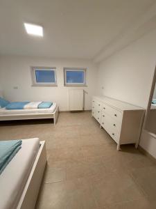 a bedroom with two beds and a dresser and two windows at MainZeit Albertshofen 2 Zimmerwohnung Parkplatz 