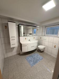 a white bathroom with a toilet and a sink at MainZeit Albertshofen 2 Zimmerwohnung Parkplatz  +6 photos