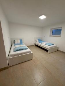 two beds in a white room with at MainZeit Albertshofen 2 Zimmerwohnung Parkplatz 
