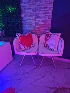 twee roze stoelen met hartjes en een kussen erop bij Love Room romantique avec jacuzzi - Arles centre in Arles