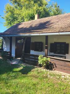a small house with a porch and a wooden fence at Birsalmafa Vendégház in Bajánsenye