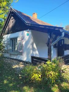 a white house with a window and a roof at Birsalmafa Vendégház in Bajánsenye +13 photos