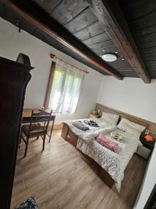 a bedroom with a bed and a table in it at Birsalmafa Vendégház in Bajánsenye