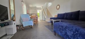 a living room with a couch and a tv at Barefoot Beach House in Larnaka