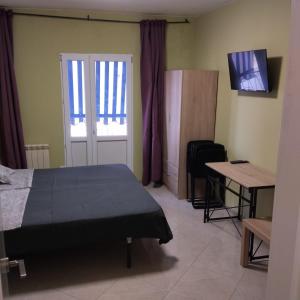 ein Schlafzimmer mit einem Bett und einem Tisch und einem Fernseher in der Unterkunft Mini-hotel Casa de la Luz in Alicante + 69 Fotos