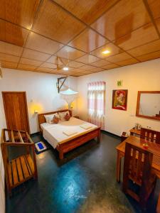 a bedroom with a bed and two chairs in it at Bright Sun Safari in Udawalawe
