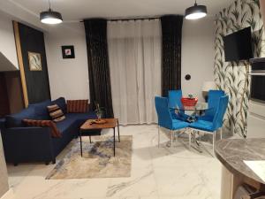 a living room with a blue couch and blue chairs at Somewhere Between Apartments in Piechowice