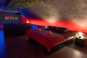 a bedroom with a bed with a red lighting at L'escapade Vosgienne, Cinéma, Balnéo in Remiremont