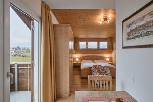 a bedroom with two beds and a balcony at Residence La Terrazza - Südtirol erleben in Kaltern am See in Caldaro