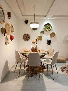 诺阿瑟Nouaceur Suite avec Piscine Casa Aéroport AirNest的一间墙上配有桌椅和盘子的用餐室 更多45张照片