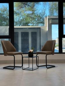 尼兹瓦Alwadi view شرفة الوادي的带窗户的客房内配有两把椅子和一张桌子